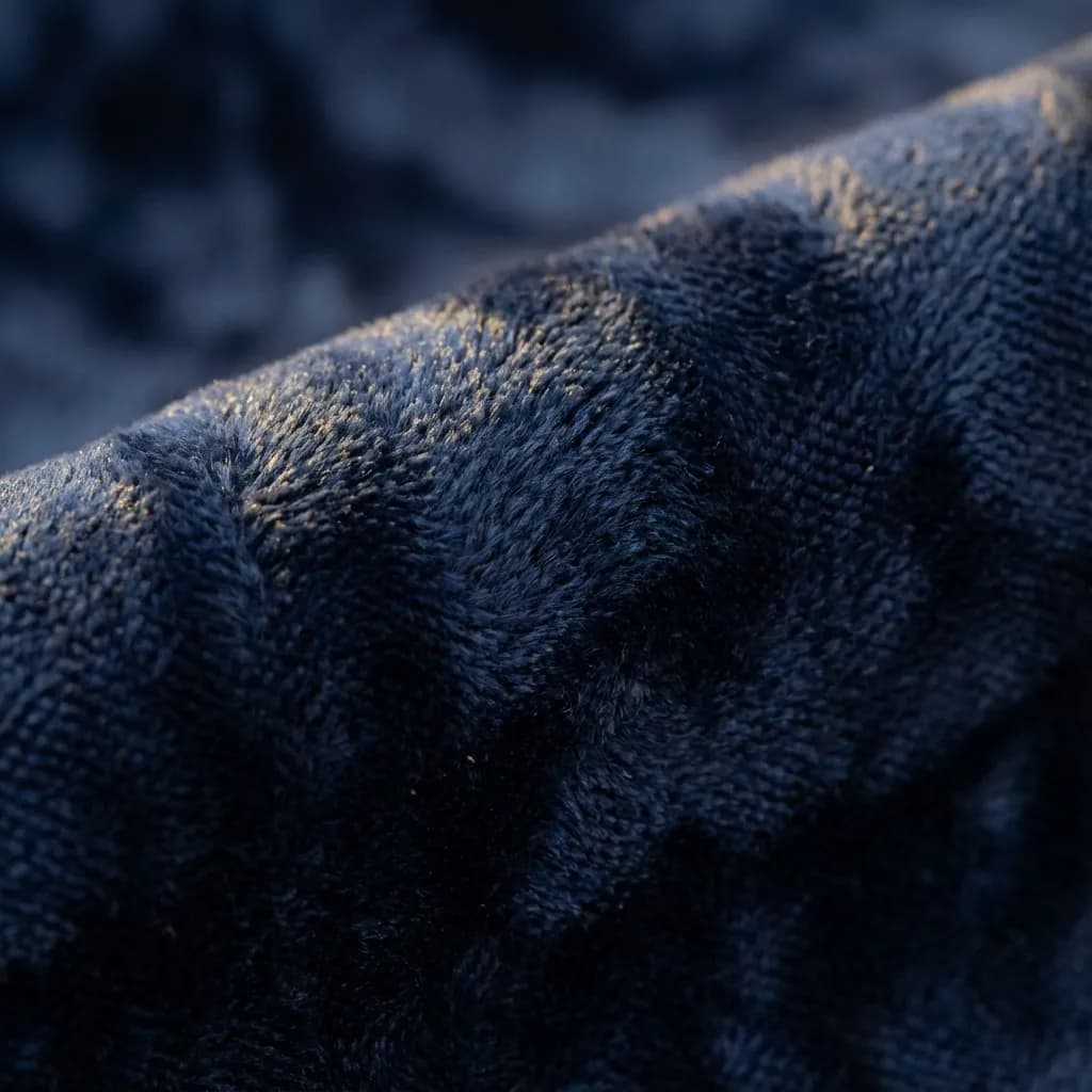 Close up of rich blue velvet fabric texture showing plush pile